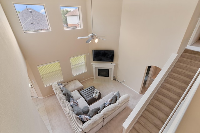 3610 Harewood Ct, Pearland, TX 77584 - living room with a fireplace, a high ceiling, ceiling fan, baseboards, and stairway