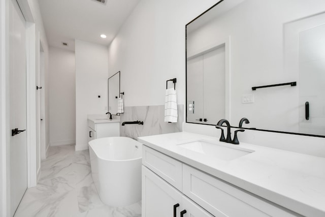 849 Mansfield St Unit F, Houston, TX 77091 - full bathroom featuring marble look tile flooring, two vanities, a freestanding bath, and recessed lighting