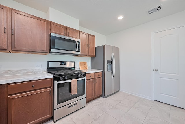 766 Hardwood Grove Ct, Houston, TX 77090 - kitchen featuring stainless steel appliances, light countertops, brown cabinetry, light tile patterned floors, and recessed lighting