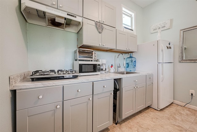 2087 Rd 5210, Cleveland, TX 77327 - kitchen featuring a sink, under cabinet range hood, stainless steel microwave, freestanding refrigerator, and light countertops