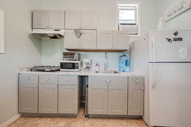 2087 Rd 5210, Cleveland, TX 77327 - kitchen featuring freestanding refrigerator, a sink, under cabinet range hood, gray cabinetry, and stainless steel microwave