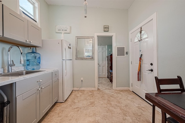 2087 Rd 5210, Cleveland, TX 77327 - kitchen featuring a sink, light countertops, gray cabinetry, freestanding refrigerator, and baseboards