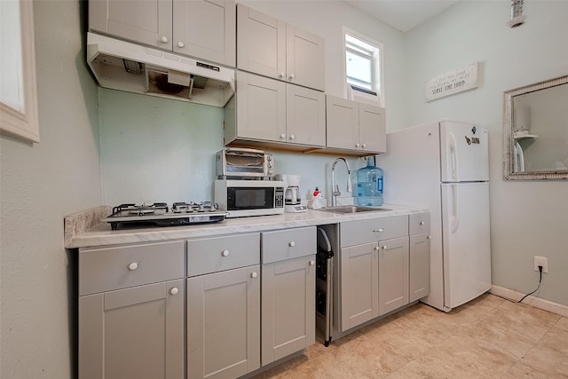 2087 Rd 5210, Cleveland, TX 77327 - kitchen featuring a sink, under cabinet range hood, freestanding refrigerator, and light countertops