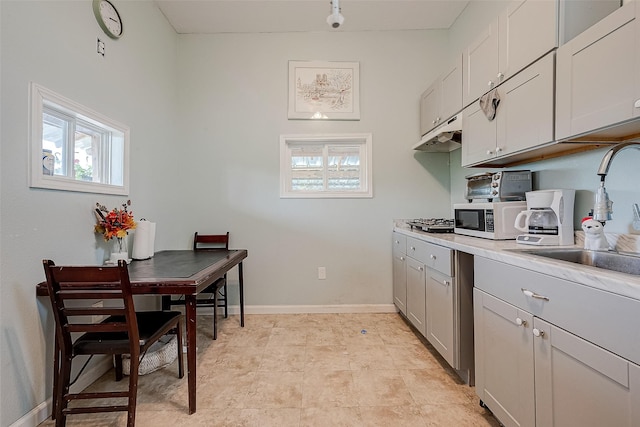 2087 Rd 5210, Cleveland, TX 77327 - kitchen featuring a sink, light countertops, stainless steel gas stovetop, gray cabinets, and baseboards