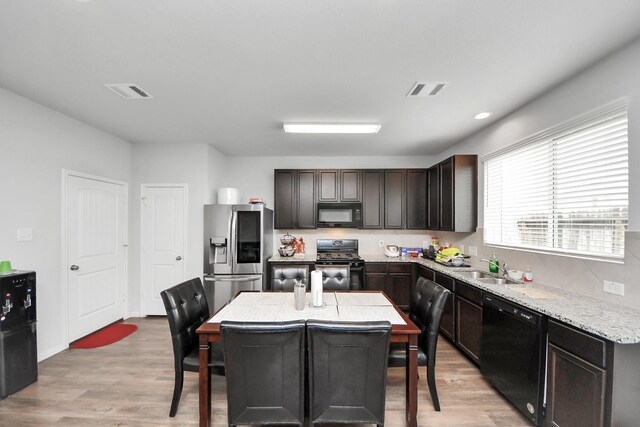 18510 Snowy River Ln, Katy, TX 77084 - kitchen with black appliances, light wood-style flooring, a sink, and dark brown cabinetry