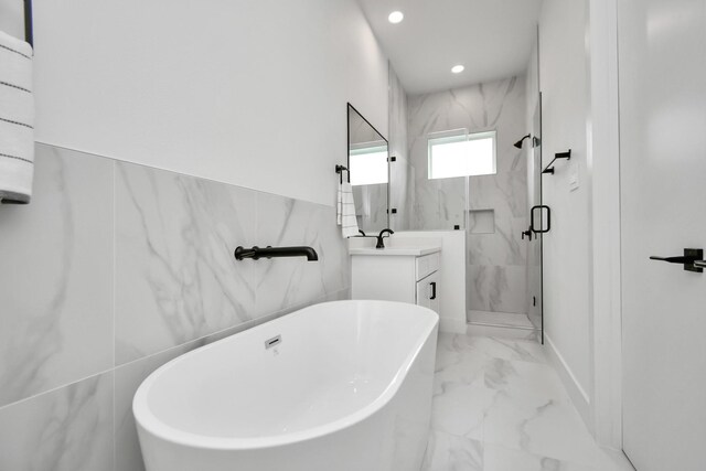 849 Mansfield St Unit A, Houston, TX 77091 - full bathroom featuring marble finish floors, a marble finish shower, a soaking tub, vanity, and recessed lighting