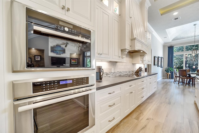 22414 Meadowhurst Cir W, Tomball, TX 77377 - kitchen with white cabinets, backsplash, ornamental molding, light wood-style floors, and dark countertops
