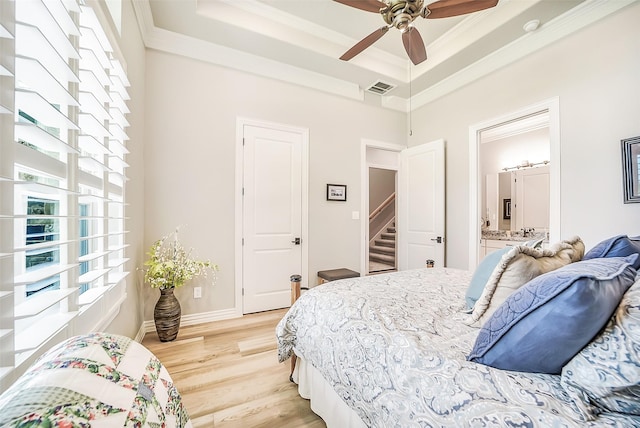 22414 Meadowhurst Cir W, Tomball, TX 77377 - bedroom featuring crown molding, a raised ceiling, light wood-type flooring, connected bathroom, and baseboards