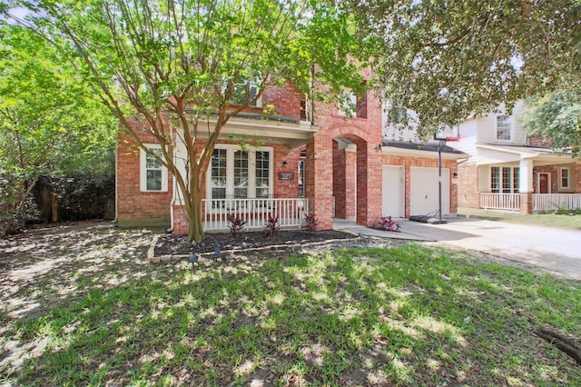 9103 Huckinston Ct, Spring, TX 77379 - view of front of house with a porch, driveway, brick siding, and an attached garage