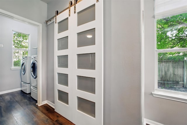 9103 Huckinston Ct, Spring, TX 77379 - washroom featuring washing machine and dryer, a barn door, dark wood finished floors, and baseboards