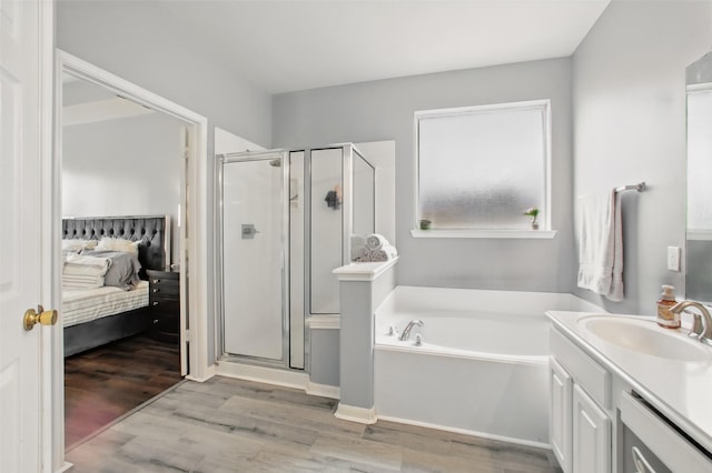 9103 Huckinston Ct, Spring, TX 77379 - ensuite bathroom featuring a shower stall, a garden tub, vanity, and wood finished floors