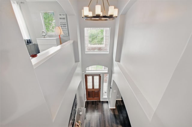 9103 Huckinston Ct, Spring, TX 77379 - entryway with wood finished floors, a chandelier, arched walkways, a towering ceiling, and baseboards