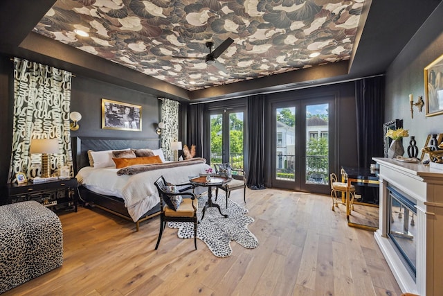 619 W 26th St, Houston, TX 77008 - bedroom featuring wood-type flooring, access to exterior, french doors, and a fireplace