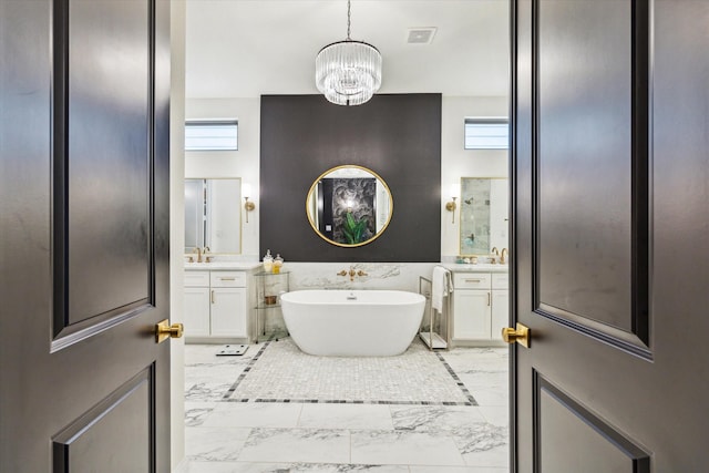 619 W 26th St, Houston, TX 77008 - bathroom with marble look tiles, vanity, a freestanding bath, and a chandelier