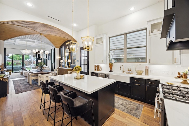 619 W 26th St, Houston, TX 77008 - kitchen featuring a chandelier, stainless steel appliances, a center island, light countertops, and light wood-style flooring