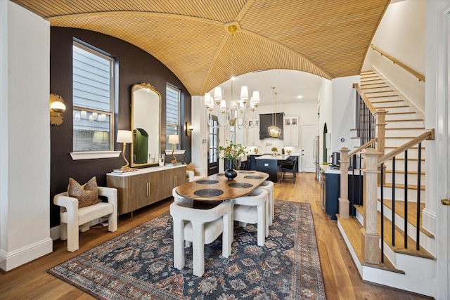 619 W 26th St, Houston, TX 77008 - dining space with stairway, a chandelier, light wood-style floors, vaulted ceiling, and baseboards