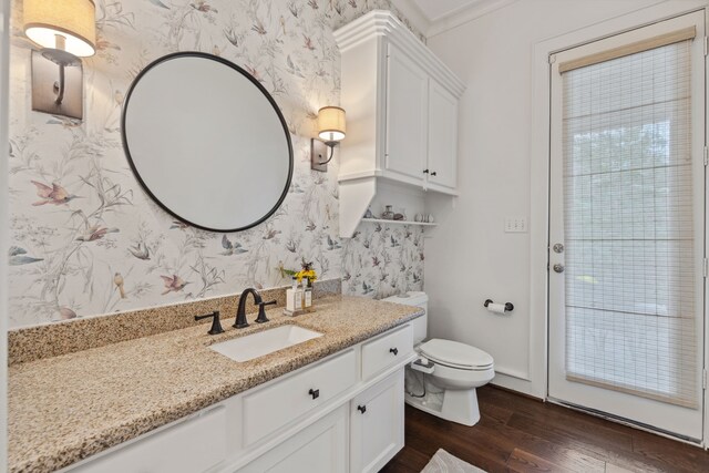 13614 Champions Centre Dr, Houston, TX 77069 - bathroom with wallpapered walls, wood finished floors, vanity, and toilet