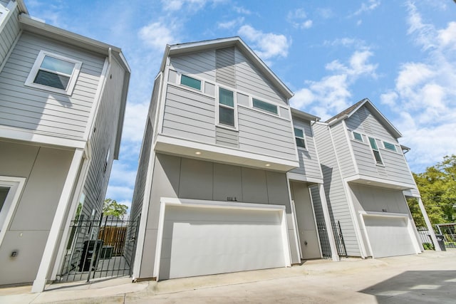 853 Mansfield St Unit B, Houston, TX 77091 - view of front facade featuring an attached garage, board and batten siding, and concrete driveway
