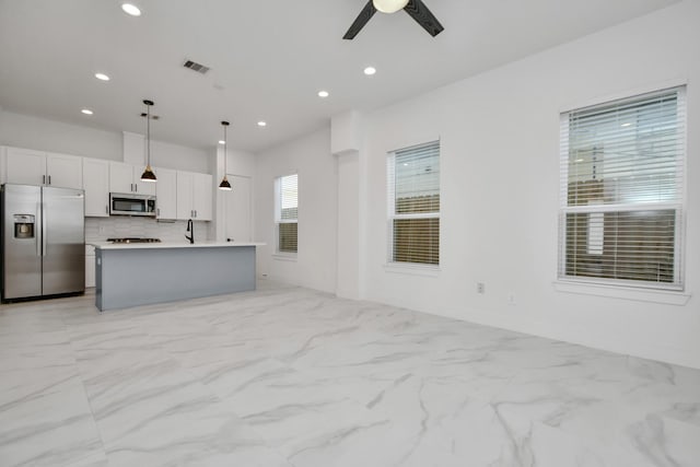 853 Mansfield St Unit B, Houston, TX 77091 - kitchen featuring appliances with stainless steel finishes, light marble finish floors, ceiling fan, light countertops, and pendant lighting