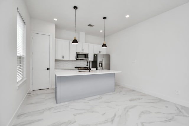 849 Mansfield St Unit B, Houston, TX 77091 - kitchen with stainless steel appliances, white cabinets, decorative backsplash, a kitchen island with sink, and plenty of natural light