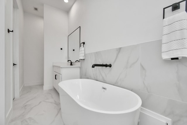 849 Mansfield St Unit B, Houston, TX 77091 - bathroom featuring a soaking tub, marble finish floors, vanity, and recessed lighting