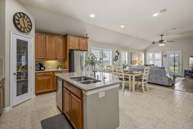 9210 Monarch Field Ln, Cypress, TX 77433 - kitchen with stainless steel appliances, lofted ceiling, open floor plan, brown cabinets, and light stone counters