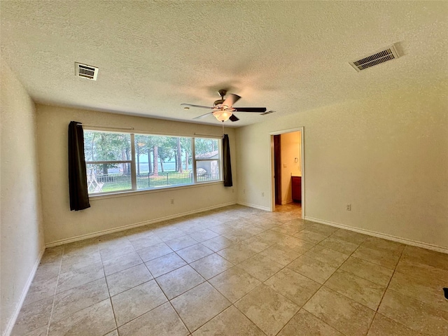86 Huntington, Trinity, TX 75862 - spare room featuring ceiling fan, light tile patterned flooring, baseboards, and a textured ceiling