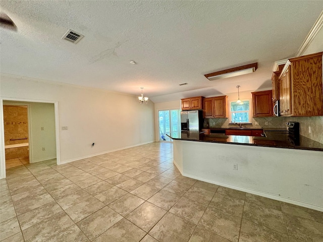 86 Huntington, Trinity, TX 75862 - kitchen with stainless steel appliances, a sink, brown cabinets, dark countertops, and a textured ceiling
