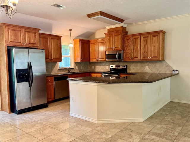 86 Huntington, Trinity, TX 75862 - kitchen featuring stainless steel appliances, tasteful backsplash, brown cabinets, a peninsula, and decorative light fixtures