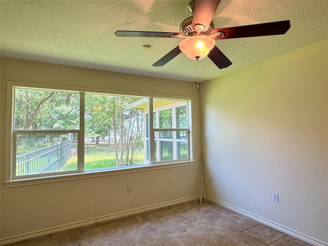 86 Huntington, Trinity, TX 75862 - empty room featuring healthy amount of natural light, carpet flooring, a textured ceiling, baseboards, and ceiling fan
