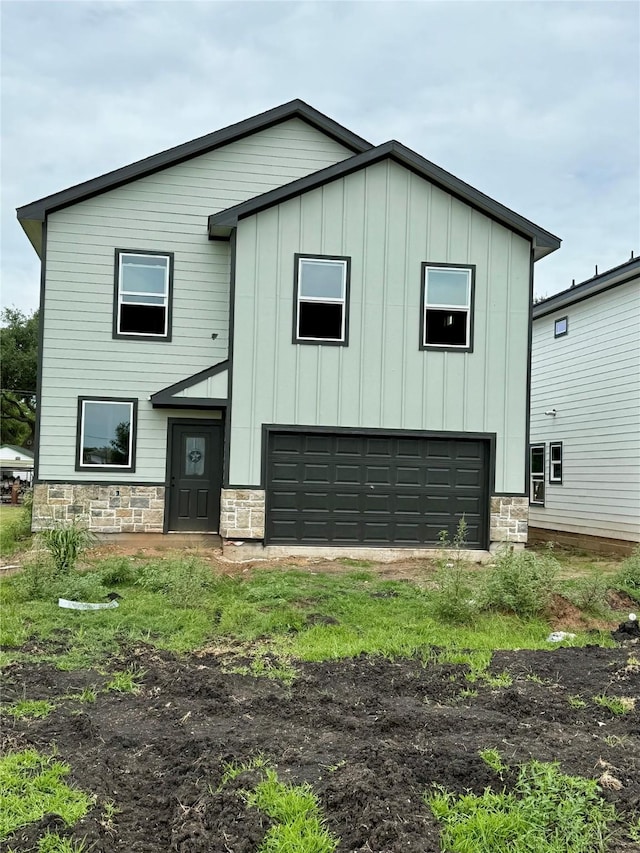 402 N 4th St, Beasley, TX 77417 - view of front facade featuring stone siding, a garage, and board and batten siding