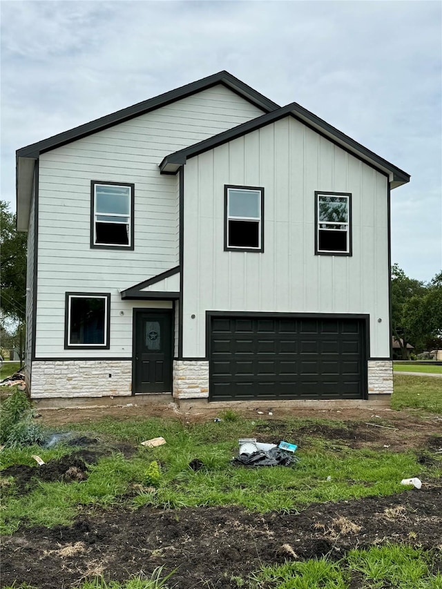 402 N 4th St, Beasley, TX 77417 - view of front facade featuring stone siding, board and batten siding, and a garage