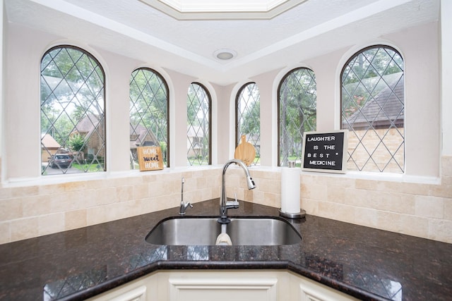 12210 Rocky Lake Ct, Houston, TX 77070 - kitchen with a sink, dark stone counters, backsplash, and white cabinets