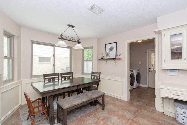 12210 Rocky Lake Ct, Houston, TX 77070 - dining space with washing machine and clothes dryer, a decorative wall, a wainscoted wall, and a textured ceiling