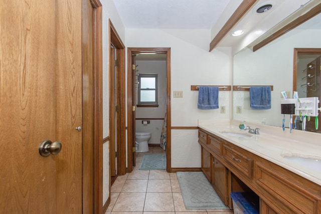 12210 Rocky Lake Ct, Houston, TX 77070 - bathroom featuring double vanity, tile patterned floors, toilet, vaulted ceiling, and baseboards