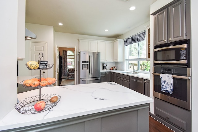 9611 Haven Crossing Ct, Houston, TX 77065 - kitchen with appliances with stainless steel finishes, a sink, gray cabinets, light stone countertops, and recessed lighting