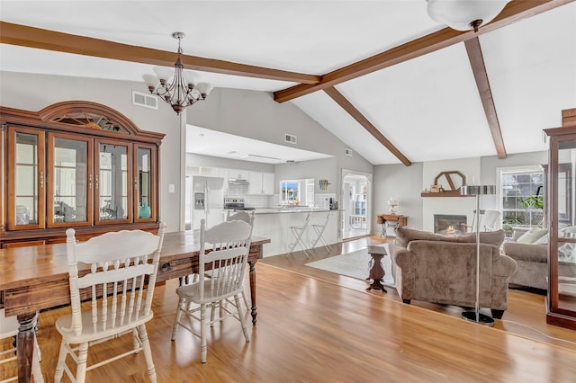 2138 Middle Creek Dr, Houston, TX 77339 - dining room with light wood finished floors, a chandelier, healthy amount of natural light, and a glass covered fireplace