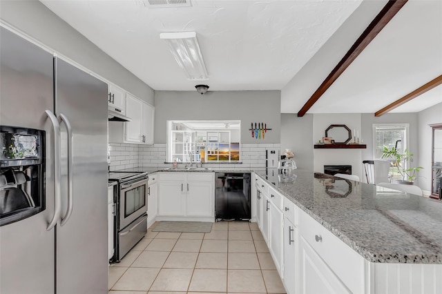 2138 Middle Creek Dr, Houston, TX 77339 - kitchen with appliances with stainless steel finishes, a peninsula, decorative backsplash, light tile patterned floors, and beamed ceiling