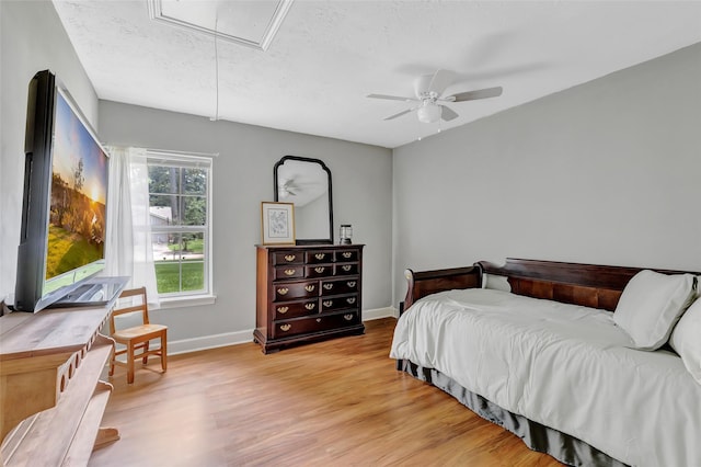 2138 Middle Creek Dr, Houston, TX 77339 - bedroom with attic access, light wood-style flooring, baseboards, a ceiling fan, and a textured ceiling