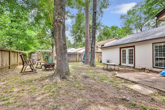 2138 Middle Creek Dr, Houston, TX 77339 - fenced backyard featuring french doors, an outdoor fire pit, and a patio area
