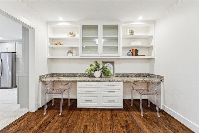 7811 Skyline Dr, Houston, TX 77063 - home office featuring built in study area, dark wood finished floors, baseboards, and built in shelves