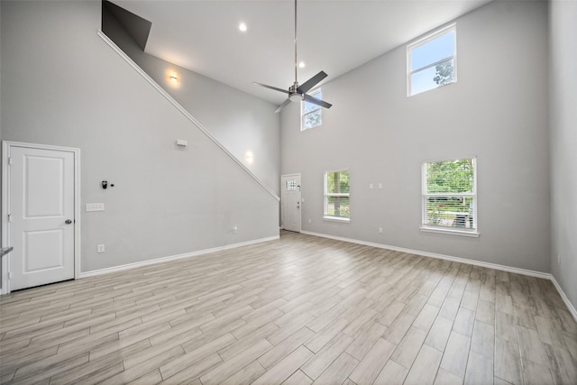 4006 Frontier Rd, Willis, TX 77378 - unfurnished living room with high vaulted ceiling, plenty of natural light, baseboards, ceiling fan, and light wood finished floors