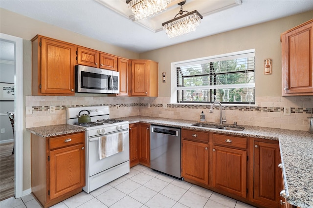 14515 Redbud Valley Trl, Houston, TX 77062 - kitchen featuring stainless steel appliances, a sink, backsplash, light stone counters, and brown cabinets