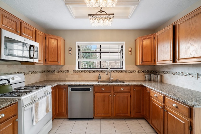 14515 Redbud Valley Trl, Houston, TX 77062 - kitchen featuring appliances with stainless steel finishes, a sink, a chandelier, and brown cabinets