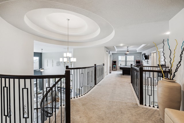 28243 Shorecrest Ln, Katy, TX 77494 - hallway with a raised ceiling, light carpet, an upstairs landing, and a chandelier