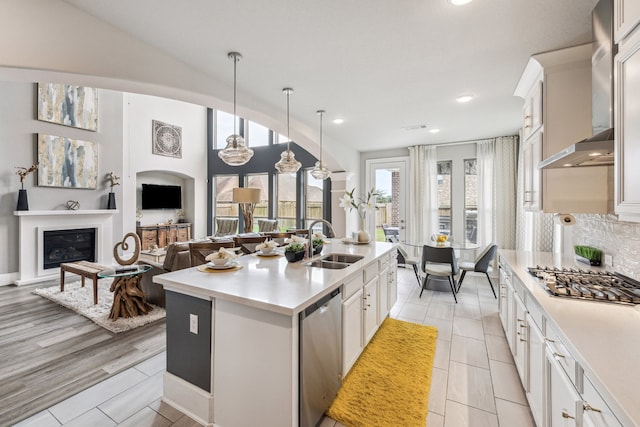 28243 Shorecrest Ln, Katy, TX 77494 - kitchen featuring stainless steel appliances, a sink, light countertops, a glass covered fireplace, and a center island with sink
