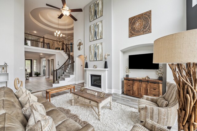 28243 Shorecrest Ln, Katy, TX 77494 - living area with a high ceiling, a ceiling fan, stairs, a chandelier, and wood finished floors