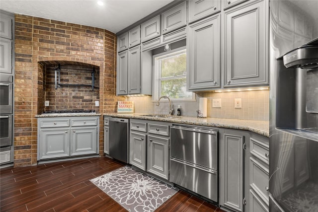 2205 Erin Glen Ct, Deer Park, TX 77536 - kitchen with gray cabinetry, stainless steel appliances, a sink, and decorative backsplash