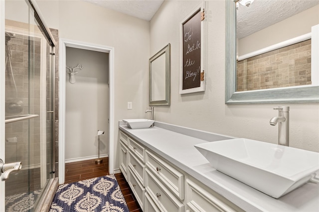 2205 Erin Glen Ct, Deer Park, TX 77536 - full bathroom with a stall shower, double vanity, a textured ceiling, and wood finish floors