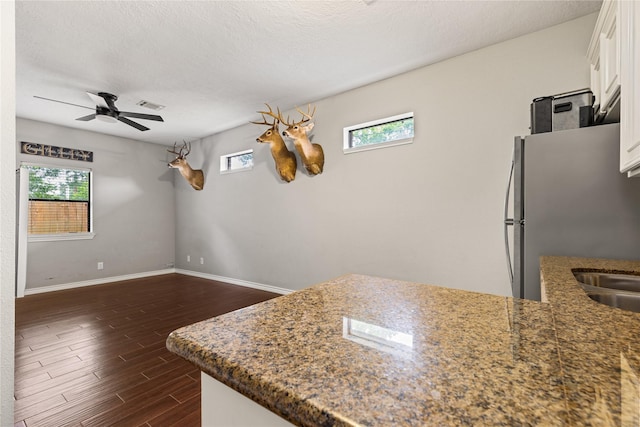 2205 Erin Glen Ct, Deer Park, TX 77536 - kitchen featuring white cabinetry, baseboards, ceiling fan, dark wood-type flooring, and dark stone counters